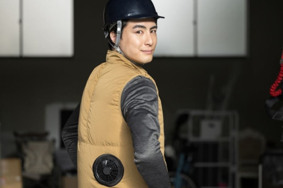 黒いヘルメットと冷却ベストを着用した男性