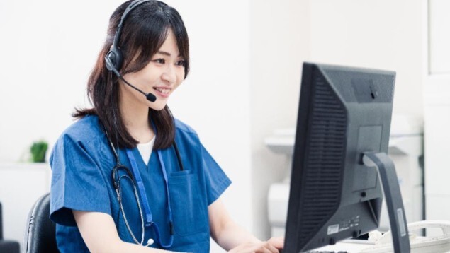 PCを操作するインカムを操作する女性